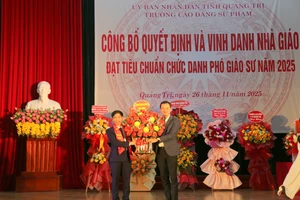 Ông Võ Văn Minh, Phó giám đốc Sở GD&ĐT Quảng Trị tặng hoa chúc mừng ông Trương Đình Thăng.