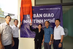 Lãnh đạo Công ty TĐQT và lãnh đạo chính quyền địa phương bàn giao nhà tình nghĩa cho bà Hoàng Thị Nhiệm.