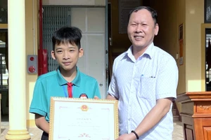 Đại diện UBND xã Vĩnh Linh tặng Giấy khen và tuyên dương em học sinh về hành động ý nghĩa.