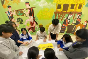 Các bạn học sinh đang học chữ Brũ- Vân Kiều thông qua sổ tay học tập ngoài giờ học.