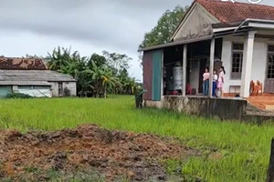 Hố sâu giữa ruộng sau vụ nổ lớn, nghi do bom sót lại.