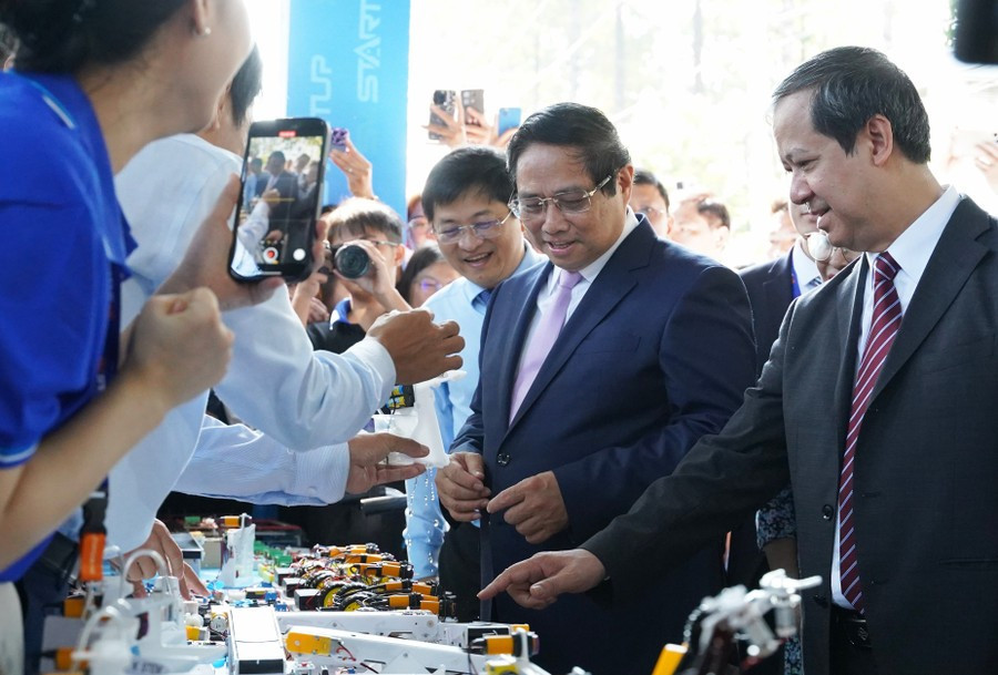 Thủ tướng Phạm Minh Chính và Bộ trưởng Bộ GD&ĐT Nguyễn Kim Sơn tham quan các gian hàng trưng bày sản phẩm tại Ngày hội Khởi nghiệp quốc gia của HSSV. Ảnh: HCMUTE 