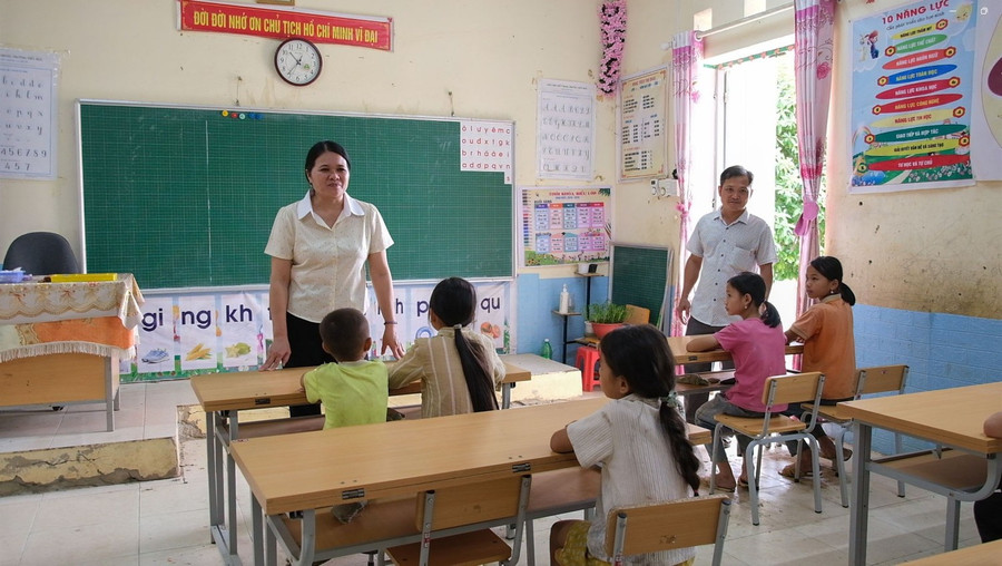 Cô giáo Lục Thị Lương, Hiệu trưởng Trường PTDTBT Tiểu học Cốc Pàng trao đổi với học sinh Điểm trường Chè Lếch. Ảnh: Quốc Tuân - Phạm Vũ.