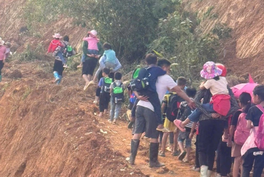 Học sinh lớp 1, lớp 2 được thầy cô Trường PTDTBT Tiểu học Bản Khoang (thị xã Sa Pa, Lào Cai) cõng đến trường. Ảnh: NTCC.