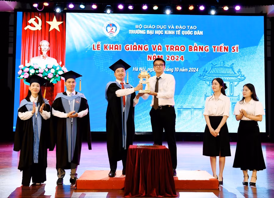 Tân Tiến sĩ trao biểu trưng của chương trình đào tạo trình độ Tiến sĩ cho các tân nghiên cứu sinh khoá 45.