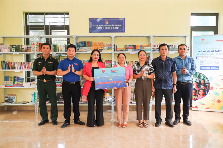 Lãnh đạo TTCNTT và Báo trao thư viện trên lũ cho xã1.jpg