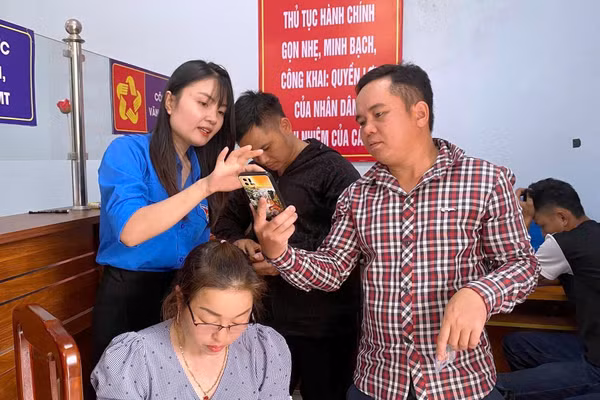 Lực lượng thanh niên xã Nam Xuân hướng dẫn người dân cài ứng dụng VNeID.