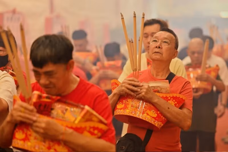 Mọi người cầu nguyện tại Đền Leong Nam trong buổi lễ chào đón Thần Tài vào đêm giao thừa Tết Nguyên đán ở Singapore. Ảnh: Caroline Chia/Reuters. hang-tram-trieu-nguoi-khap-chau-a-mung-nam-con-ran-13.jpg