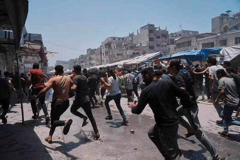 Người Palestine bỏ chạy sau cuộc không kích của Israel vào Thành phố Gaza. Ảnh: AP chum-anh-khoanh-khac-mot-cuoc-khong-kich-vao-thanh-pho-gaza-07.jpg