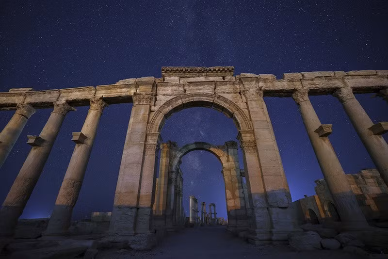Lối vào Nhà hát La Mã ở cuối con đường có hàng cột trong tàn tích thành phố cổ Palmyra, dưới bầu trời đầy sao ở Syria sáng 28/8. chum-anh-ve-dep-co-kinh-tan-tich-palmyra-syria-05.jpg