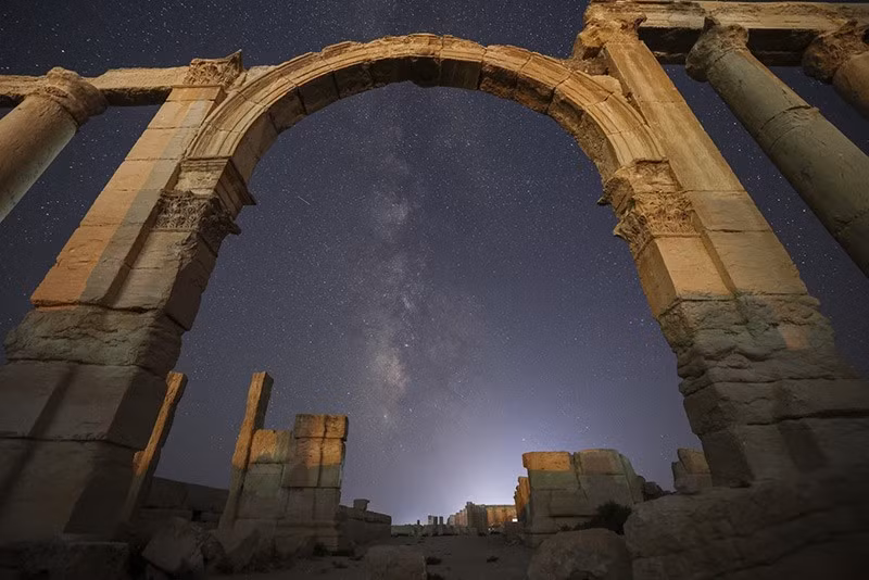 Lối vào khu vực Nhà hát La Mã, một phần của tàn tích thành phố cổ Palmyra, dưới bầu trời đầy sao ở Syria tối 27/8. Ảnh: AP. chum-anh-ve-dep-co-kinh-tan-tich-palmyra-syria-01.jpg