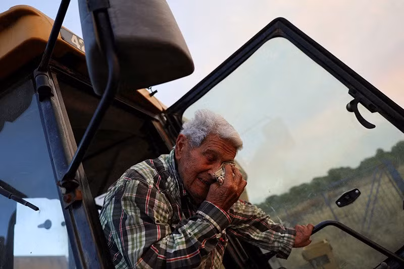 Cụ ông Paco Amposta, 90 tuổi, đang điều khiển máy xúc để dọn sạch cánh đồng quanh nhà nhằm đối phó với cháy rừng, gần Xerta – một trong những ngôi làng bị phong tỏa tại tỉnh Tarragona, vùng Catalonia, Tây Ban Nha, ngày 8/7. chum-anh-chay-rung-bung-phat-o-chau-au-0705-02.jpg