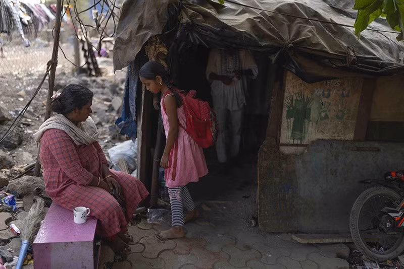 Unnati Pradeep, 11 tuổi, đang nói chuyện với mẹ bên ngoài ngôi nhà của cô bé ở Thane gần Mumbai. Ảnh: AP. chum-anh-ngoi-truong-duoi-duong-cao-toc-o-an-do-09.jpg