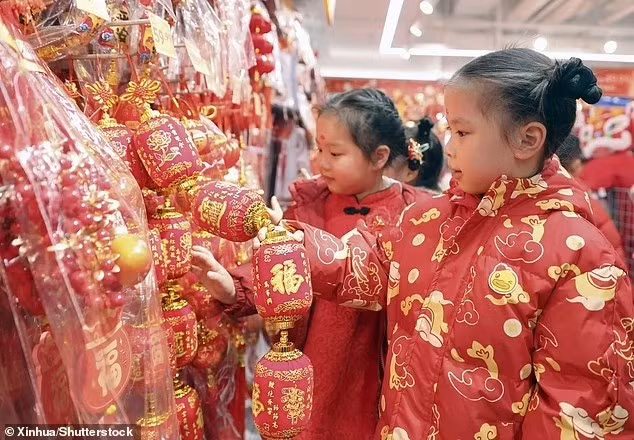 Trẻ em chọn đồ trang trí Tết Nguyên đán tại một siêu thị ở thành phố Vũ Hán vào đầu tháng này. chum-anh-vu-han-ruc-ro-don-tet-sau-5-nam-toi-boi-vi-covid-19-7.jpg