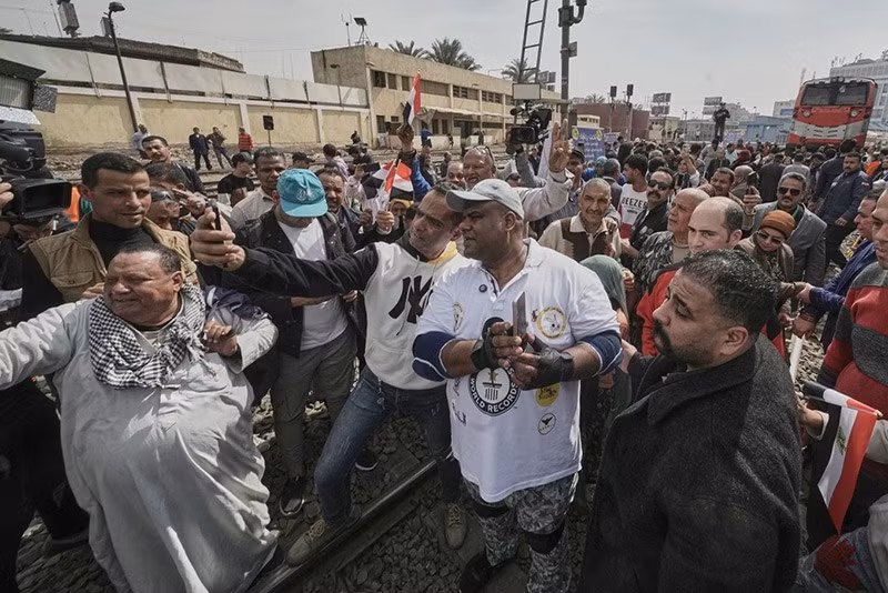 Kabonga được người hâm mộ chào đón khi chuẩn bị kéo đoàn tàu gần 10 mét tại ga Ramses, Cairo, Ai Cập, dưới sự quan sát của sách kỷ lục Guinness World Records chum-anh-nguoi-dan-ong-ai-cap-rung-rang-keo-tau-hoa-03.jpg
