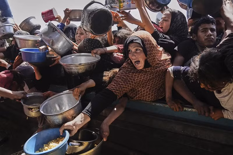 Người dân Palestine đấu tranh để có được thực phẩm tại một bếp ăn cộng đồng ở Khan Younis, phía Nam Dải Gaza, ngày 9/5. (Ảnh AP/Abdel Kareem Hana) chum-anh-lhq-canh-bao-ke-hoach-phan-phoi-vien-tro-gaza-0505-01.jpg