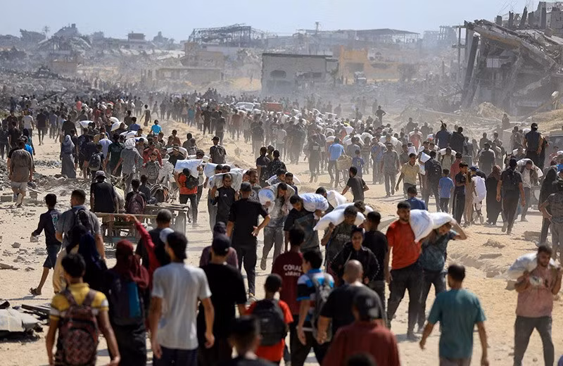Người dân Palestine tập trung mang theo hàng viện trợ vừa được chuyển vào Gaza qua Israel, giữa cuộc khủng hoảng đói nghèo, tại Beit Lahia, phía bắc Dải Gaza, 20/7. Ảnh: Reuters. chum-anh-nan-doi-ngay-cang-nghiem-trong-o-dai-gaza-0705-03.jpg