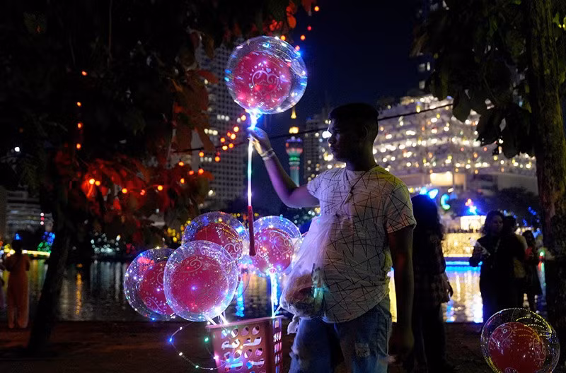 Một người bán bóng bay đang chờ khách hàng tại khu vực lễ hội Vesak chính, vào Ngày Vesak tại Colombo, Sri Lanka ngày 12/5. Ảnh: REUTERS/Thilina Kaluthotage chum-anh-dai-le-phat-dan-vesak-0505-010.jpg