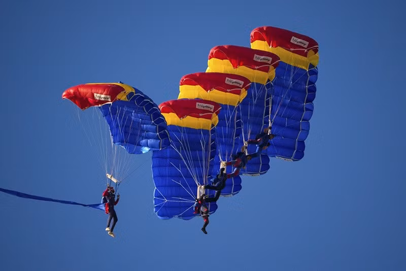 Các lính dù Romania lướt qua bầu trời phía trên sân bay Aurel Vlaicu trong ngày đầu tiên của triển lãm. chum-anh-trien-lam-hang-khong-quoc-te-bucharest-2025-05.jpg