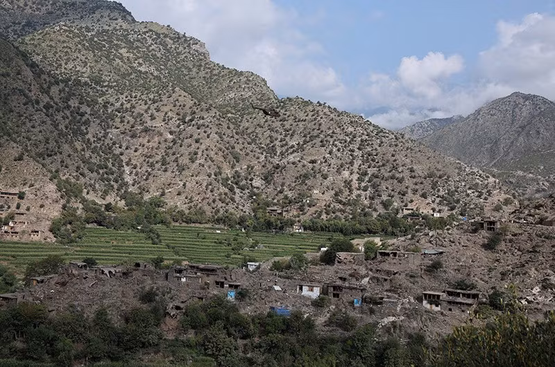 Trực thăng quân sự Taliban bay qua ngôi làng bị tàn phá sau trận động đất. Ảnh: Reuters chum-anh-chay-dua-cuu-ho-nan-nhan-dong-dat-o-afghanistan-014.jpg