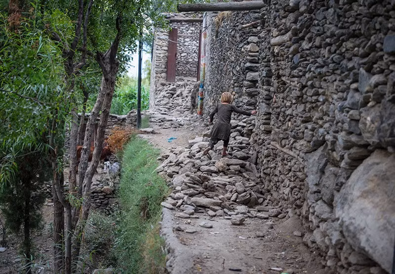 Một bé gái Afghanistan đi trên đống đổ nát của một ngôi nhà sau trận động đất. Ảnh: Reuters chum-anh-chay-dua-cuu-ho-nan-nhan-dong-dat-o-afghanistan-04.jpg