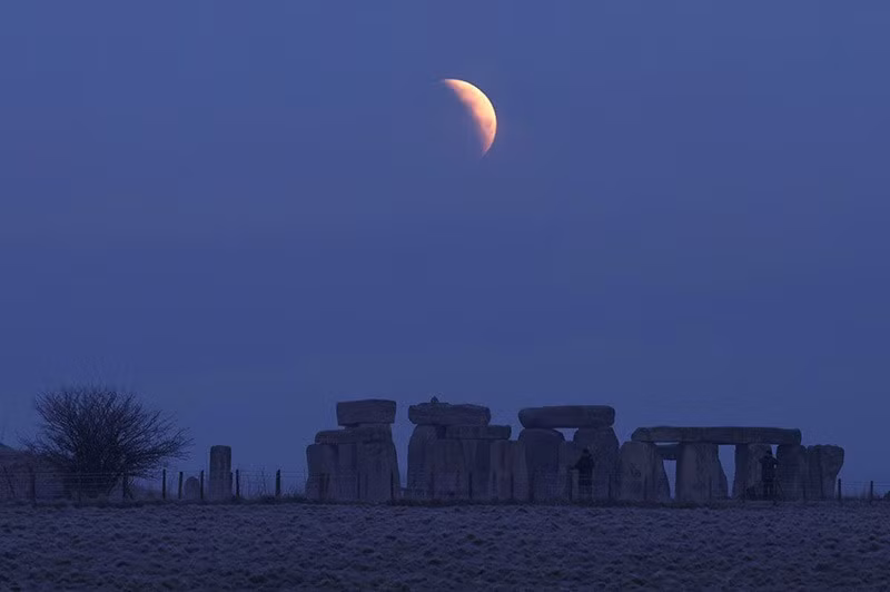 Mặt trăng di chuyển vào bóng tối của Trái đất trong quá trình nguyệt thực, nhìn từ Stonehenge gần Amesbury, Anh ngày 14/3. Ảnh: Toby Melville/Reuters. chum-anh-trang-mau-thang-3-thap-sang-bau-troi-02.jpg