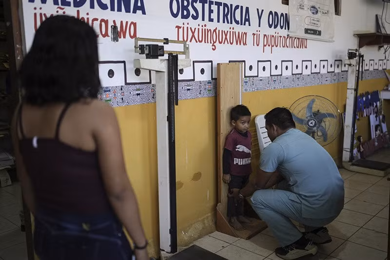 Một bác sĩ đo chiều cao cho trẻ em tại trạm y tế ở Santa Rosa, Peru. (Ảnh: AP) chum-anh-cuoc-song-o-dao-santa-rosa-015.jpg