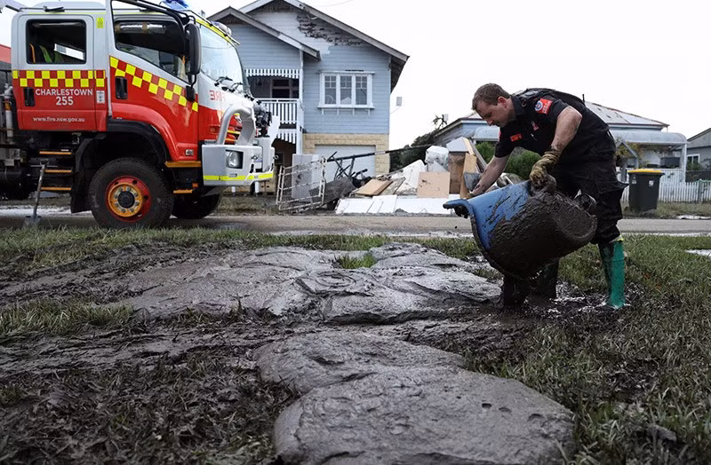 Một thành viên của Đội Cứu hỏa và Cứu hộ New South Wales đang đổ bùn mà anh đã lấy ra khỏi một ngôi nhà bị lũ lụt ở Smithtown, ngày 26/5. Ảnh: REUTERS/Hollie Adams chum-anh-nguoi-uc-khac-phuc-hau-qua-tran-lu-chet-nguoi-0505-017.jpg