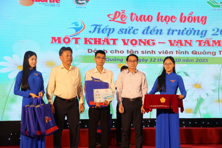 Ông Mai Huy Phương - Phó giám đốc Sở GD&ĐT Quảng Trị (bên phải) trao học bổng cho tân sinh viên. hoc-bong-4.jpg