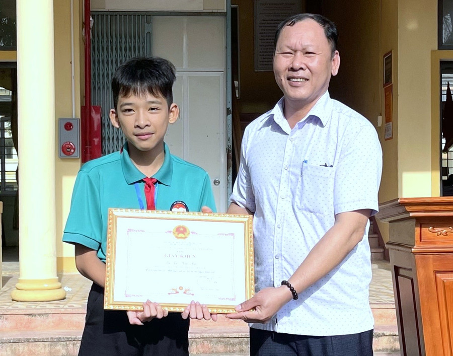 Đại diện UBND xã Vĩnh Linh tặng Giấy khen và tuyên dương em học sinh về hành động ý nghĩa.