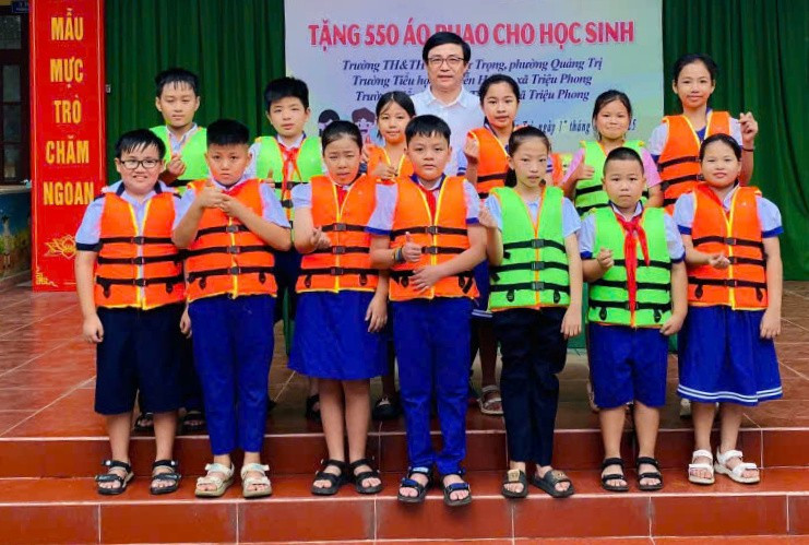 Trao tặng áo phao cho học sinh vùng chịu ảnh hưởng của lũ lụt.