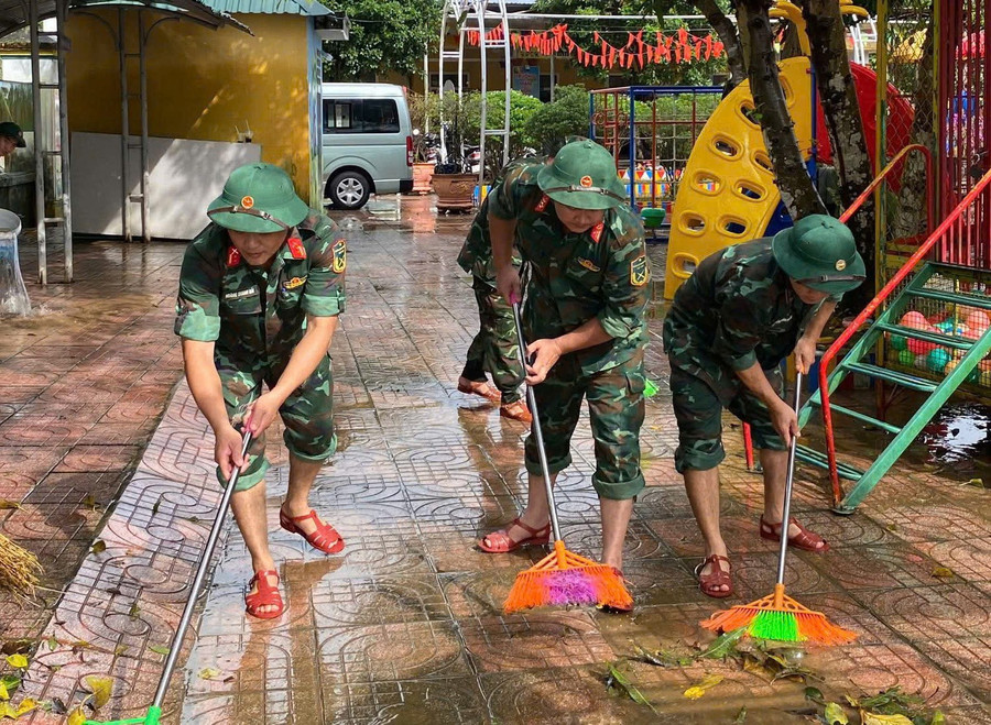 Bộ đội tham gia quét dọn vệ sinh khuôn viên trường học.