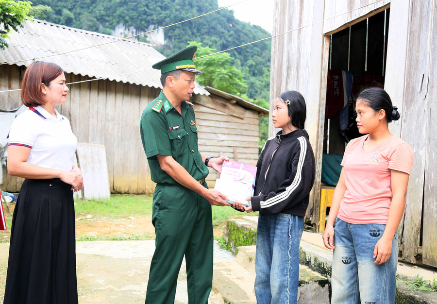 Thượng tá Dương Đình Hoàn, Chính trị viên Đồn Biên phòng Cà Xèng tặng quà học sinh khó khăn. (Ảnh: T. Chuyên) bs7a41251.jpg