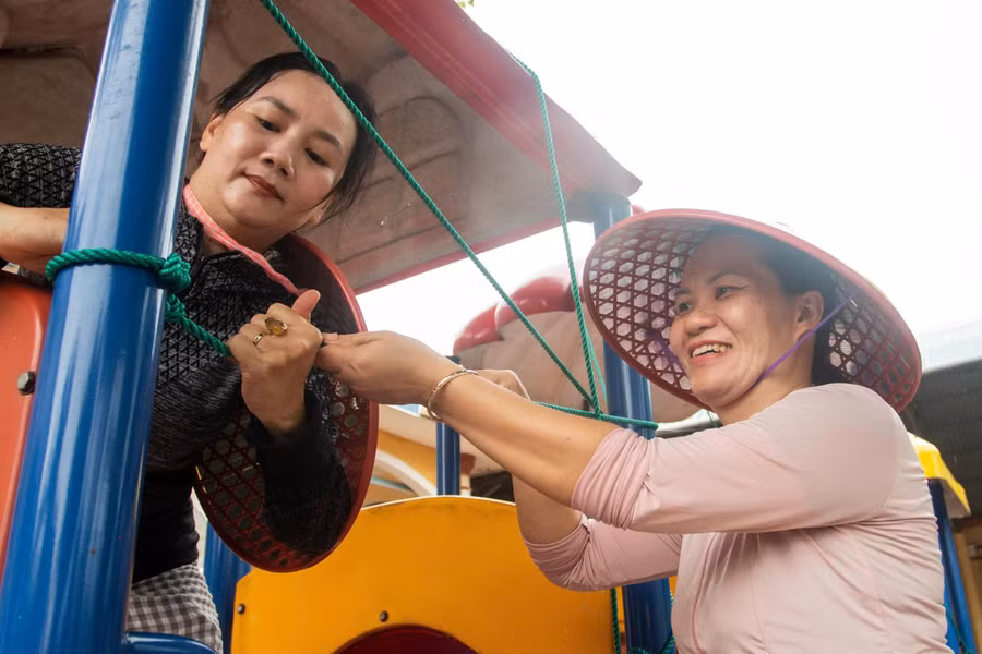 Giáo viên buộc lại các dụng cụ vui chơi của trẻ. 