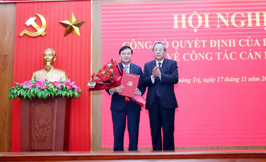 Ông Hoàng Đăng Quang, Phó Trưởng Ban Thường trực Ban Tổ chức Trung ương trao quyết định và tặng hoa chúc mừng ông Lê Hồng Vinh.