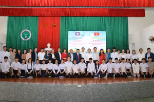 Lãnh đạo các sở, ngành, Ban giám hiệu nhà trường chụp ảnh với các em lưu học sinh Lào. (Ảnh: Phạm Tâm)