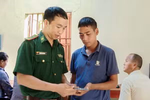 Cán bộ Biên phòng hướng dẫn người dân sử dụng ứng dụng VNeID. (Ảnh: Hải Thượng)