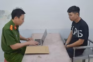 Công an lấy lời khai của Bàn Văn Vỹ. (Ảnh: CANA)