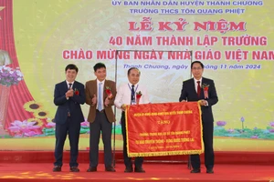 Chính quyền huyện Thanh Chương trao tặng cờ thi đua cho Trường THCS Tôn Quang Phiệt. (Ảnh: Phạm Tâm)