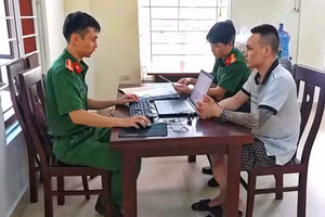 Công an lấy lời khai Lê Minh Dũng. (Ảnh: CANA)