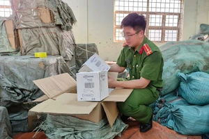 Công an kiểm tra số hàng giả. (Ảnh: CANA)