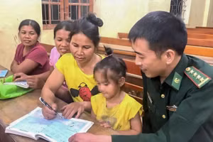 Cán bộ Biên phòng hướng dẫn học viên lớp xóa mù chữ. (Ảnh: CSCC)