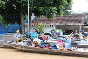 Người dân Nghệ An ở trên thuyền khi nhà cửa bị lũ nhấn chìm. (Ảnh: Phạm Tâm)