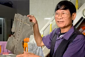 Ông Võ Văn Hoan cầm trên tay mảnh xác máy bay. (Ảnh: Phạm Tâm).