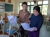 Giáo viên Trường Tiểu học Phạm Hồng Thái (Lam Thành, Nghệ An) kiểm tra lại đồ dùng, sách vở học sinh sau lũ. Ảnh Hồ Lài