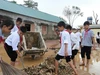 Học sinh Trường THCS Kỳ Tân, xã Tân Kỳ, Nghệ An tham gia dọn dẹp, vệ sinh sân trường sau lũ. Ảnh: Hồ Lài
