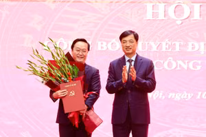 Bí thư Thành ủy Hà Nội Nguyễn Duy Ngọc trao quyết định và tặng hoa chúc mừng ông Nguyễn Đức Trung. Ảnh: VT.