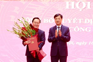 Bí thư Thành ủy Hà Nội Nguyễn Duy Ngọc trao quyết định và tặng hoa chúc mừng ông Nguyễn Đức Trung. Ảnh: VT.