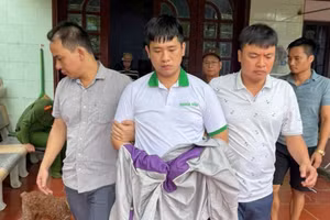 Nguyễn Hoài Nam (giữa) bị bắt giữ.