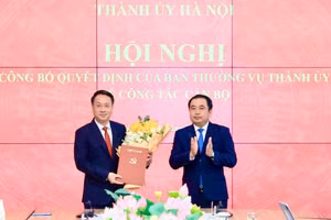 Bí thư Thành ủy Hà Nội Trần Đức Thắng trao quyết định và tặng hoa chúc mừng ông Trần Đình Cảnh. Ảnh QT.